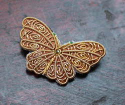 Broche papillon en broderie d’art, ornée de motifs dorés